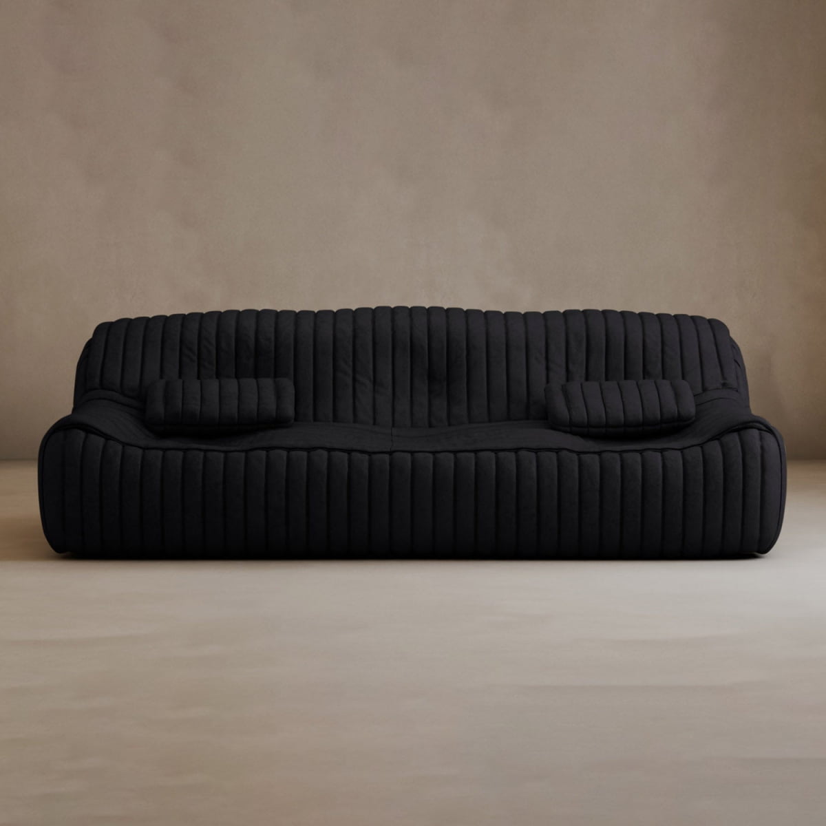 A modern, low-profile Calypso Armchair in black features a vertical tufted stripe design and includes two matching rectangular cushions, set against a plain beige wall and floor.