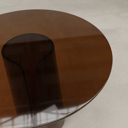 The Disc Side Table Short features a modern round acrylic top with a brown tint and a unique curved central support. Its lightweight design adds subtle retro vibes to any smooth, light-colored floor while beautifully reflecting light.