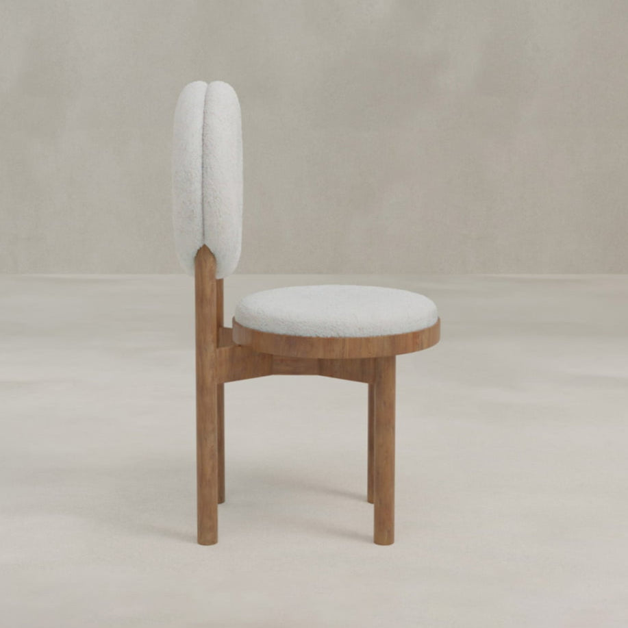 The Nola + Donut Dining Set features a modern wooden chair with a circular, cushioned white seat and a round, padded white backrest, displayed in profile against a simple, light-toned background.