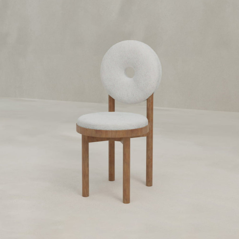 The Nola + Donut Dining Set features a modern chair with a round, donut-shaped white backrest and seat on three wooden legs, perfect for minimalist interiors.