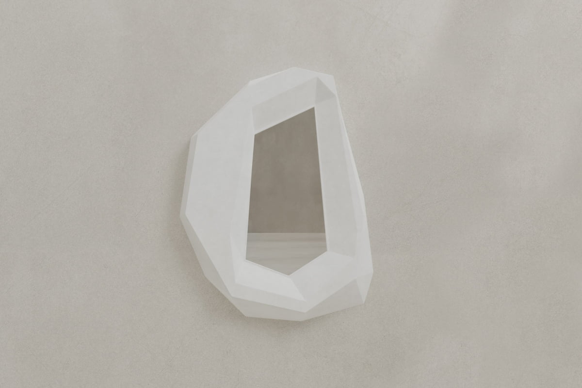 The Facet Mirror Large features a white frame and irregular polygonal edges, adding modern sophistication to any space. Its gemstone-inspired design stands out elegantly against a light gray textured wall.