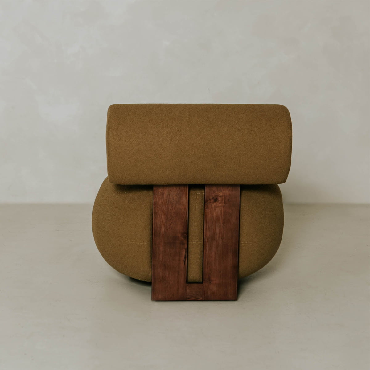 The Finchley Chair features solid legs, an olive green cushion, and a rectangular wooden backrest, set against a plain light gray background.