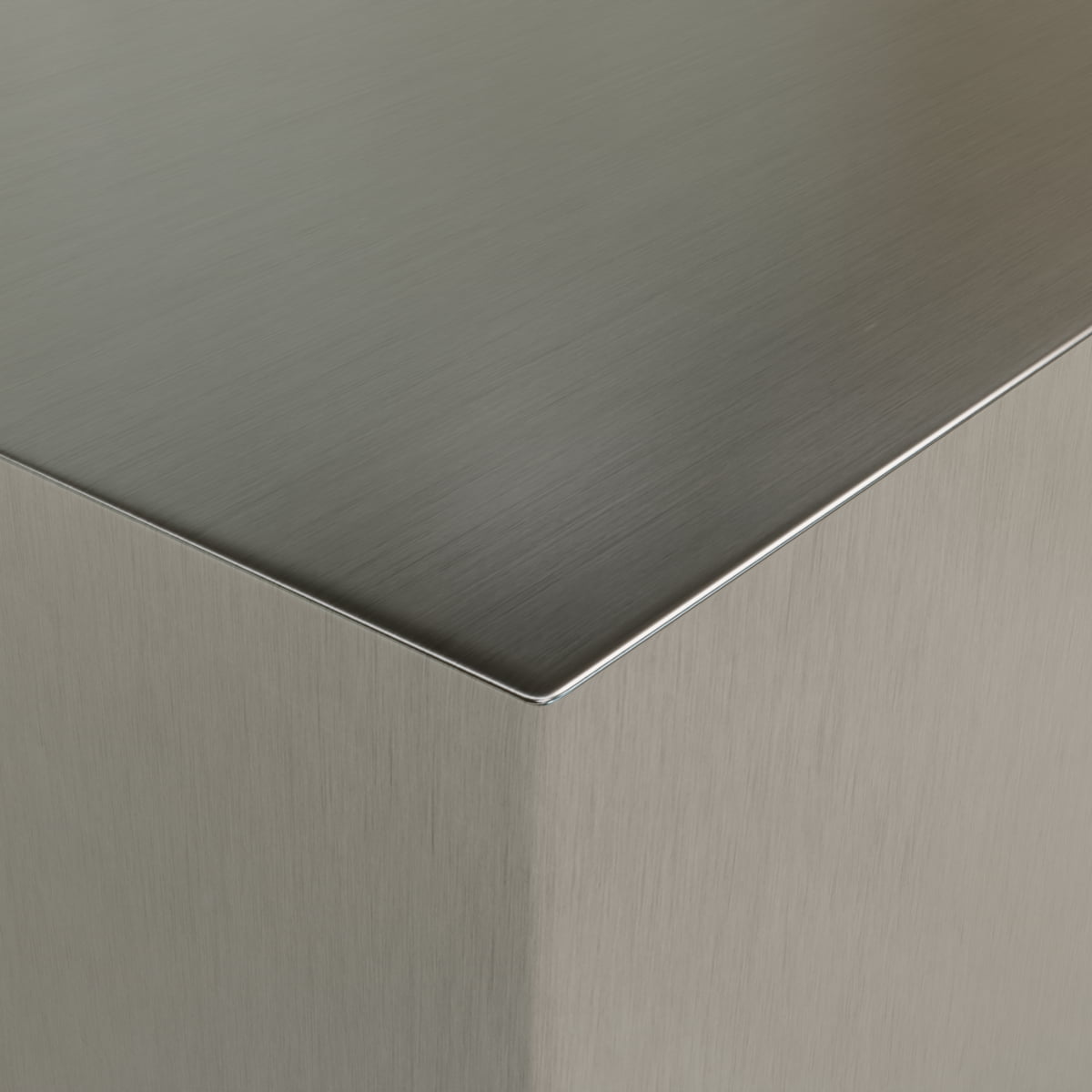 Close-up of the sharp corner of the Forge Steel Cube Plinth, highlighting its brushed metal surface with clean lines and a smooth, reflective finish that brings industrial flair to modern design.
