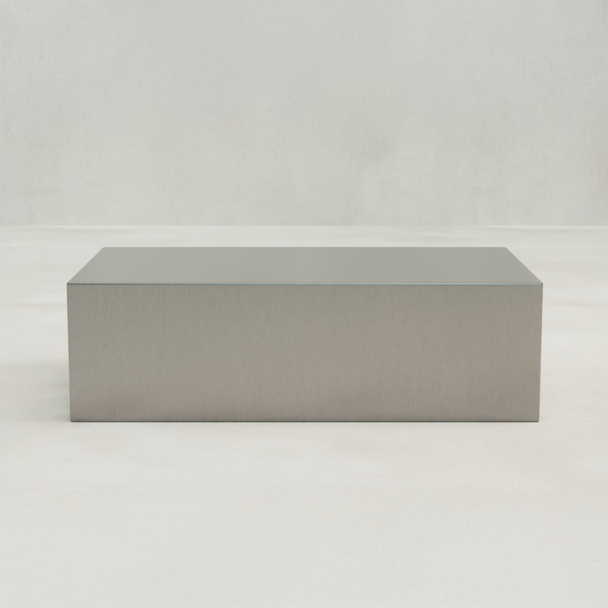 The Forge Steel Large Rectangular Plinth, featuring a minimalist modern design, sits on a smooth light-colored floor against a plain light-gray wall.