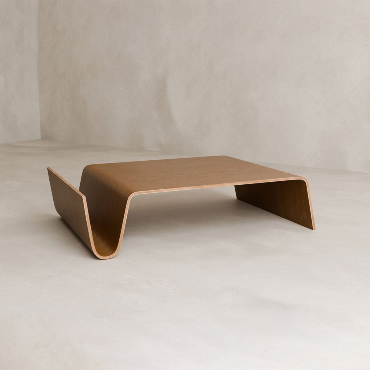 The Gregory Coffee Table features a modern, minimalist design crafted from a single piece of bent wood with smooth, asymmetric curves, a built-in magazine shelf, and adds elegance to any softly lit living space.