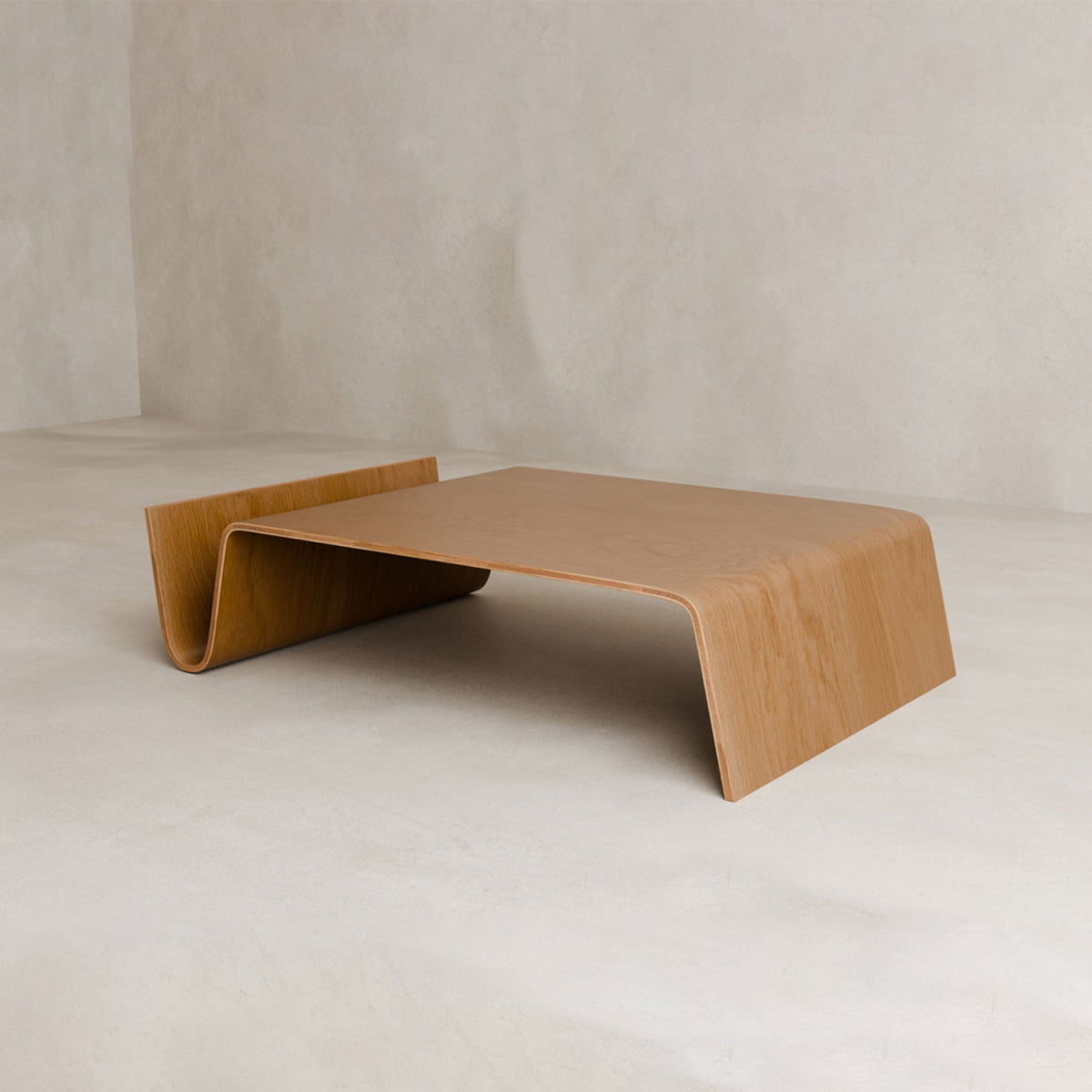 The Gregory Coffee Table features a minimalist wooden build with a smooth, wave-like design and an integrated magazine shelf, showcased against a plain, neutral background.
