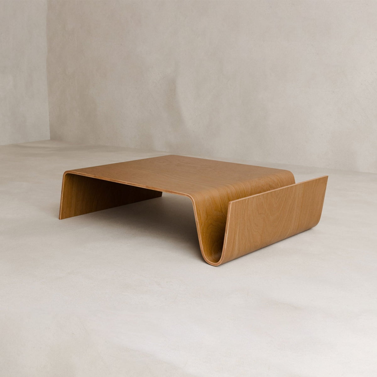 The Gregory Coffee Table features a minimalist, wave-like shape with smooth curved edges, crafted from a single piece of bent wood. This modern piece includes a convenient magazine shelf and fits perfectly in any living space.