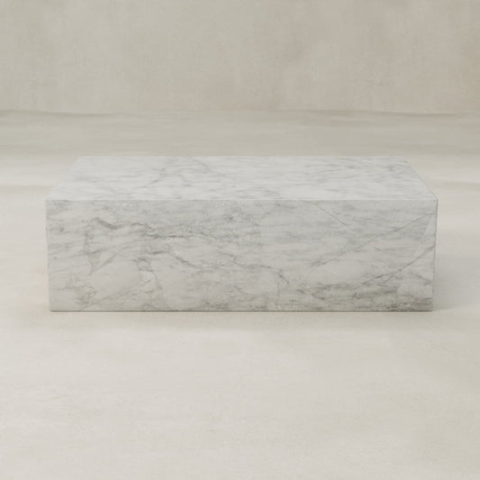 The Griselle Marble Coffee Table features a rectangular shape with grey veining and a minimalist, modern design. Its sculptural look adds elegance to any living space, beautifully complementing light, neutral backgrounds.