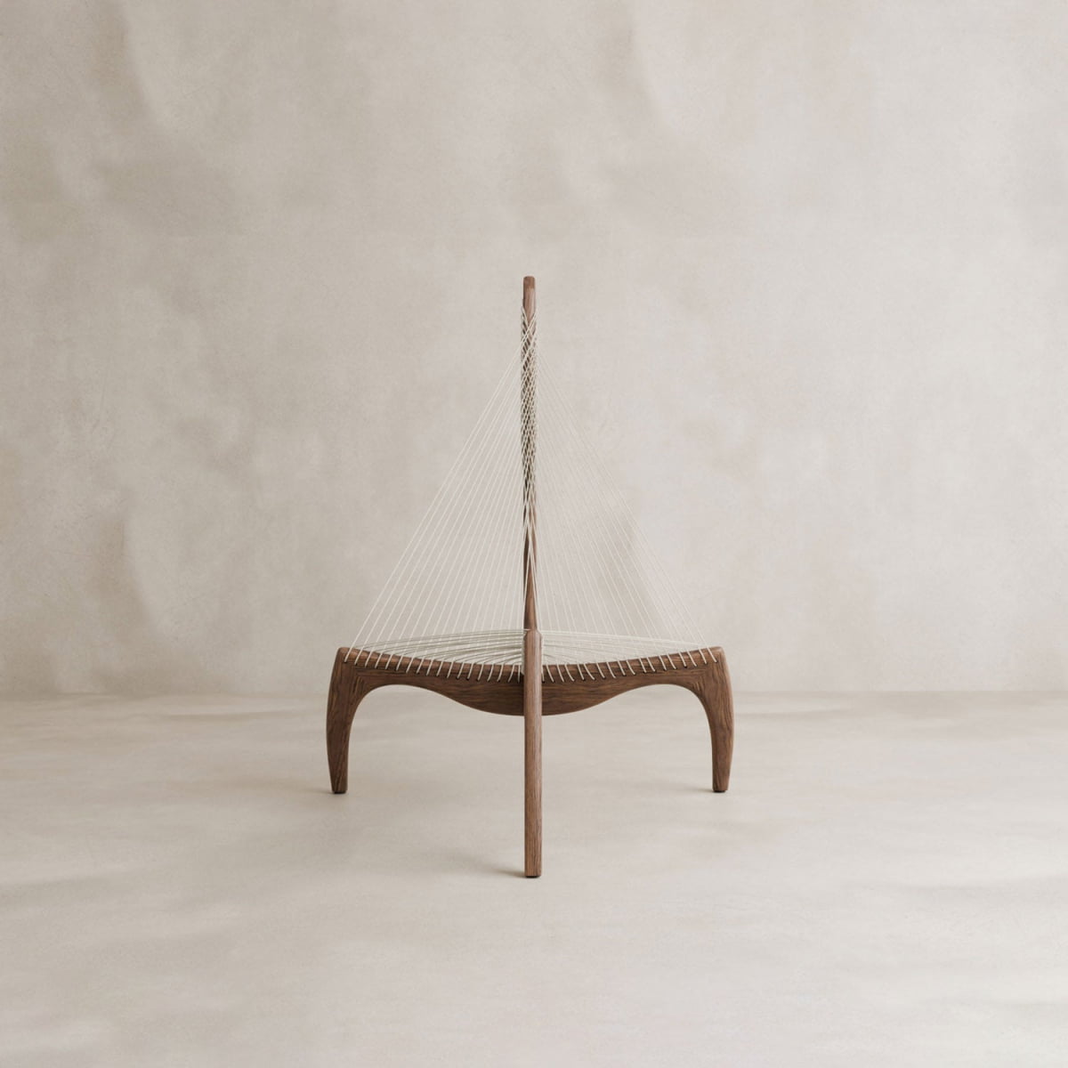 The Harp Chair features a Danish-inspired design with an ash wood frame, curved legs, and white cords fanning diagonally from the center to the edges, all set against a neutral beige background.