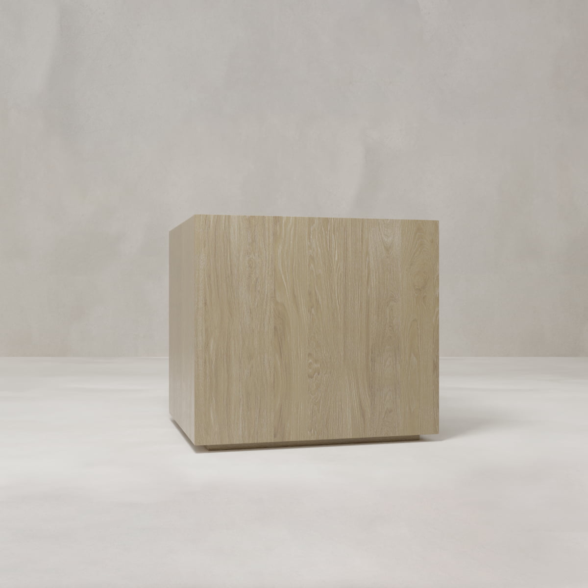 The Henley Nightstand, crafted from light wood, stands centered on a smooth white surface with a neutral gray backdrop, evoking an elegant and understated charm.
