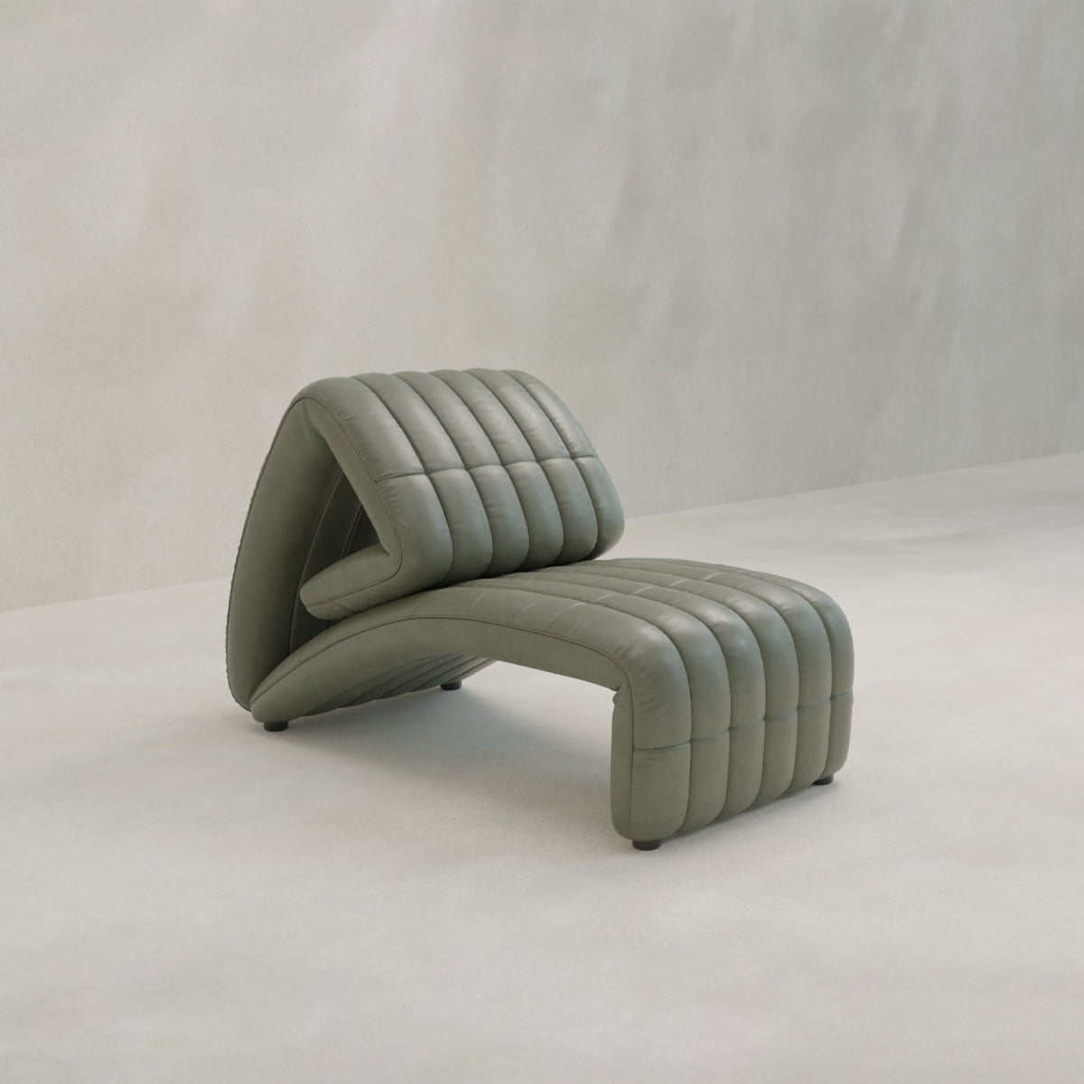 The Hillier Chair is a sculptural lounge chair with ribbed, padded sections, upholstered in premium vintage leather, perfect for a minimalist space with light walls and floors.