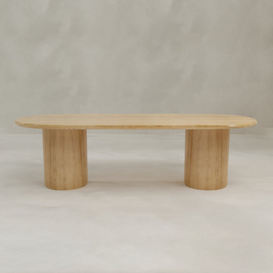 The Lancaster Oval Dining Table showcases a modern design with a smooth, high-quality wood oval top and two cylindrical ribbed bases, perfect for contemporary dining spaces.
