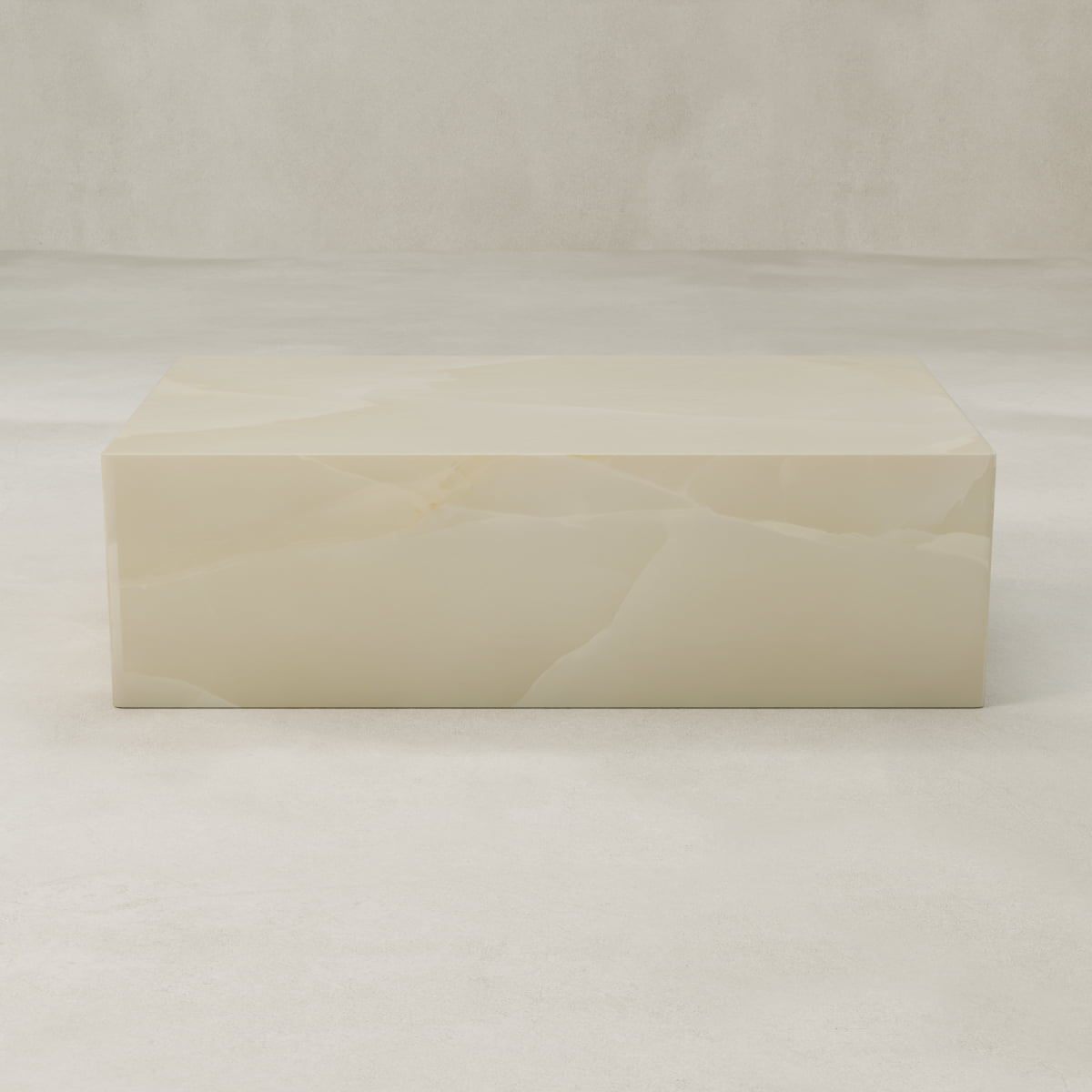 The Lunelle Onyx Coffee Table features a rectangular, smooth surface with a milky hue and subtle golden veining, shown against a neutral light background.
