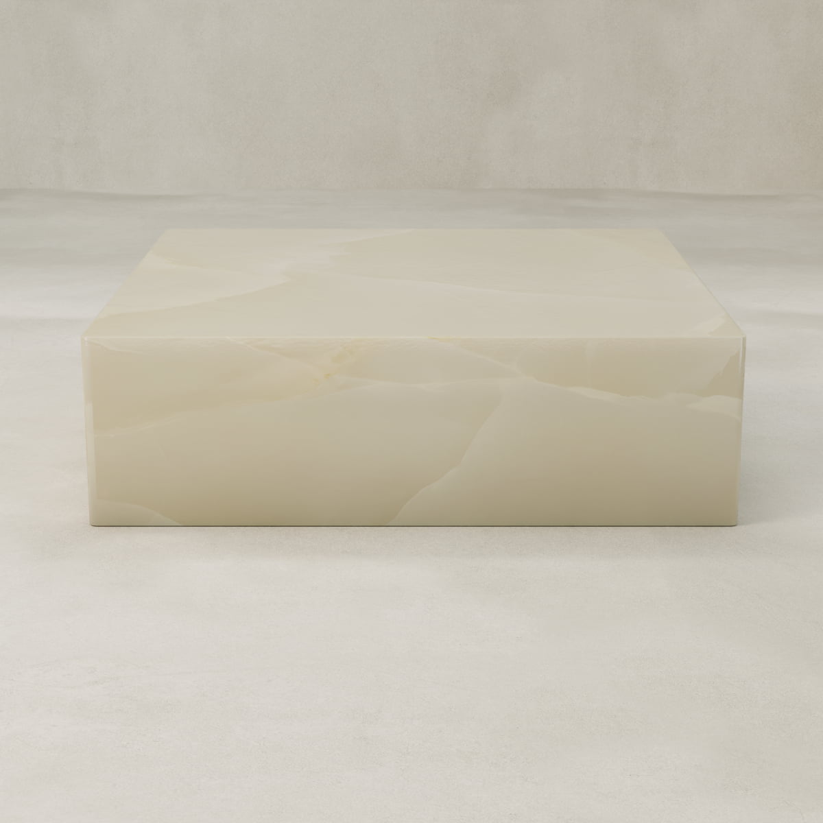 The Lunelle Onyx Coffee Table XL is a square, cream-hued piece with a polished surface and delicate golden veining, set in a minimal, light-toned room featuring matching floors and background.