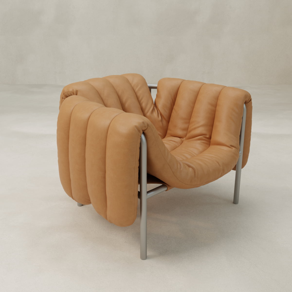 The Mallow Chair features tan leather cushions with deep channeled tufting and a sculptural tubular frame, shown against a light, neutral background.