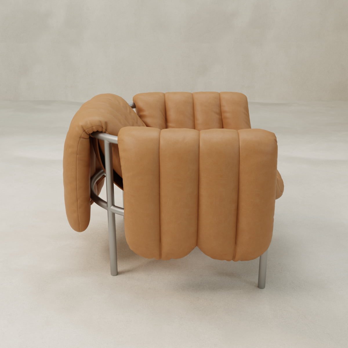 The Mallow Chair features thick tan leather cushions with deep channeled tufting and a sleek sculptural tubular frame, shown against a plain light background.