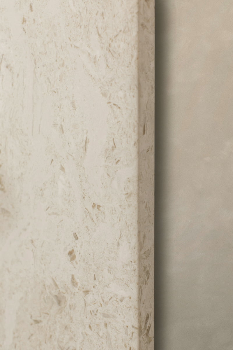 A close-up shows a textured beige wall with a rough surface next to a smooth light gray wall, creating a striking contrast—an ideal backdrop for the Marbella Floor Mirror or pairing with travertine stone accents.