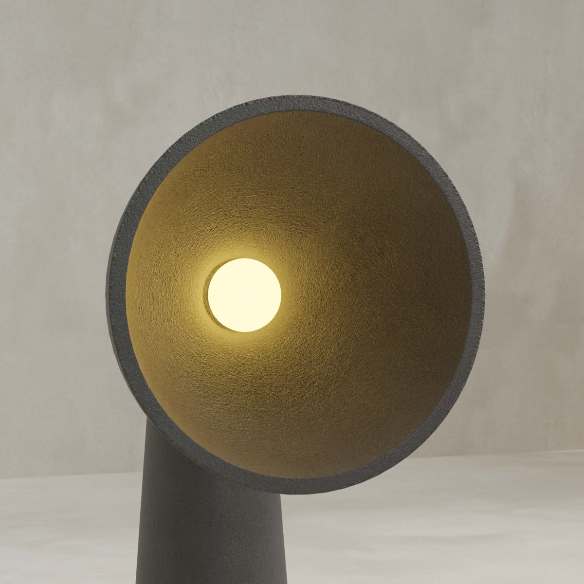 The Orbis Tall Floor Lamp features a large conical shade with a gold textured interior, casting a warm yellow glow against a plain light gray background and showcasing its sculptural, organic design.