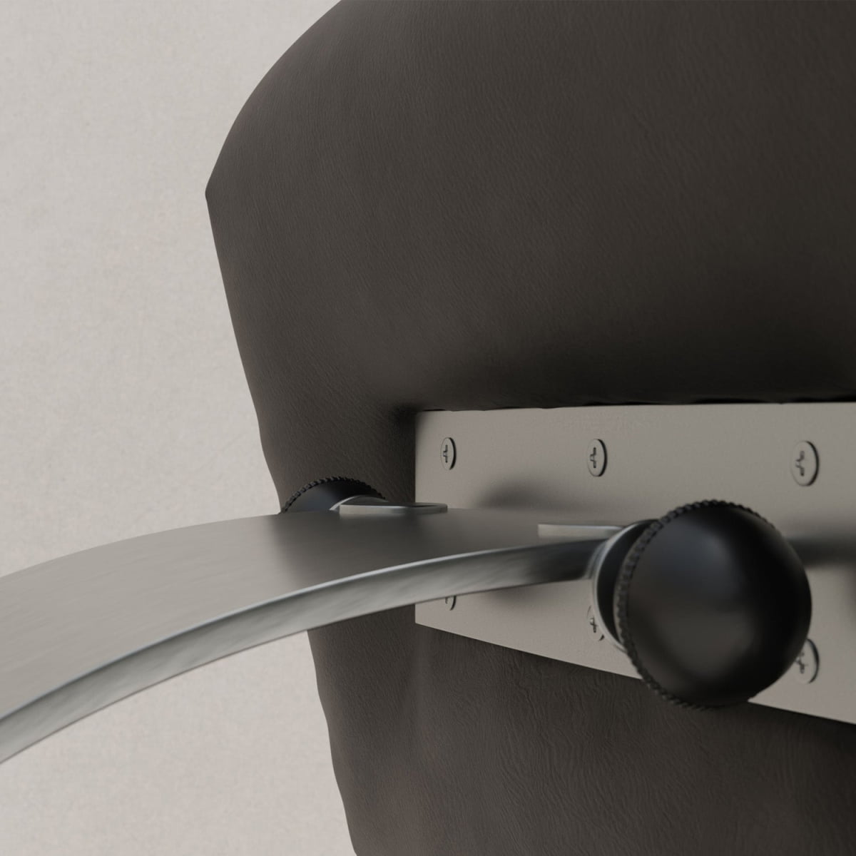 Close-up of the sleek bent metal base adjustment mechanism with screws and two black knobs on the back of the cushioned Paolo Chair With Ottoman in dark brown, highlighting its sophisticated touch to modern design.