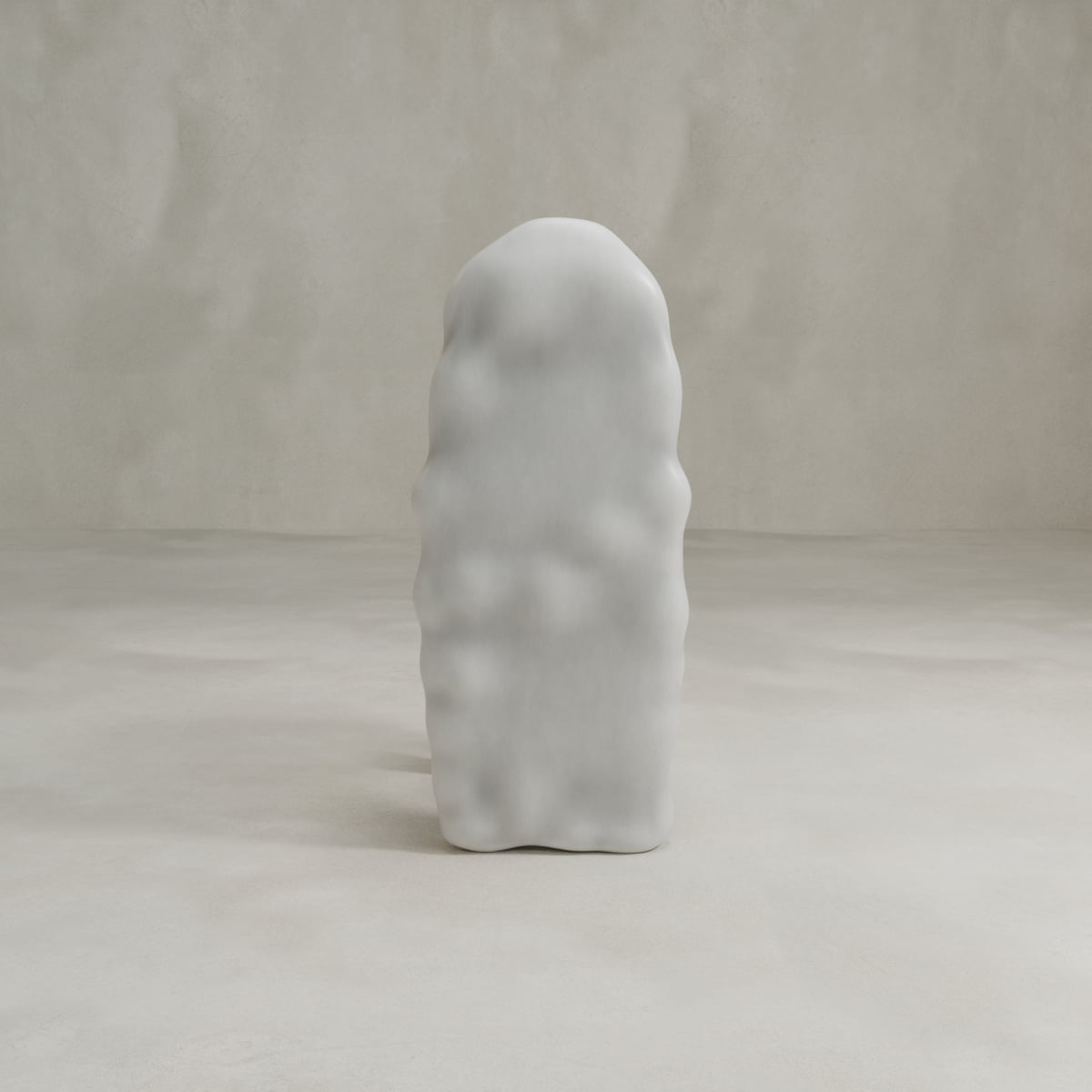 The Phantom Chair, a tall, white, abstract piece with a wavy surface, stands upright in a minimalist, light-toned room with textured walls and floor, reflecting the essence of modern craftsmanship.