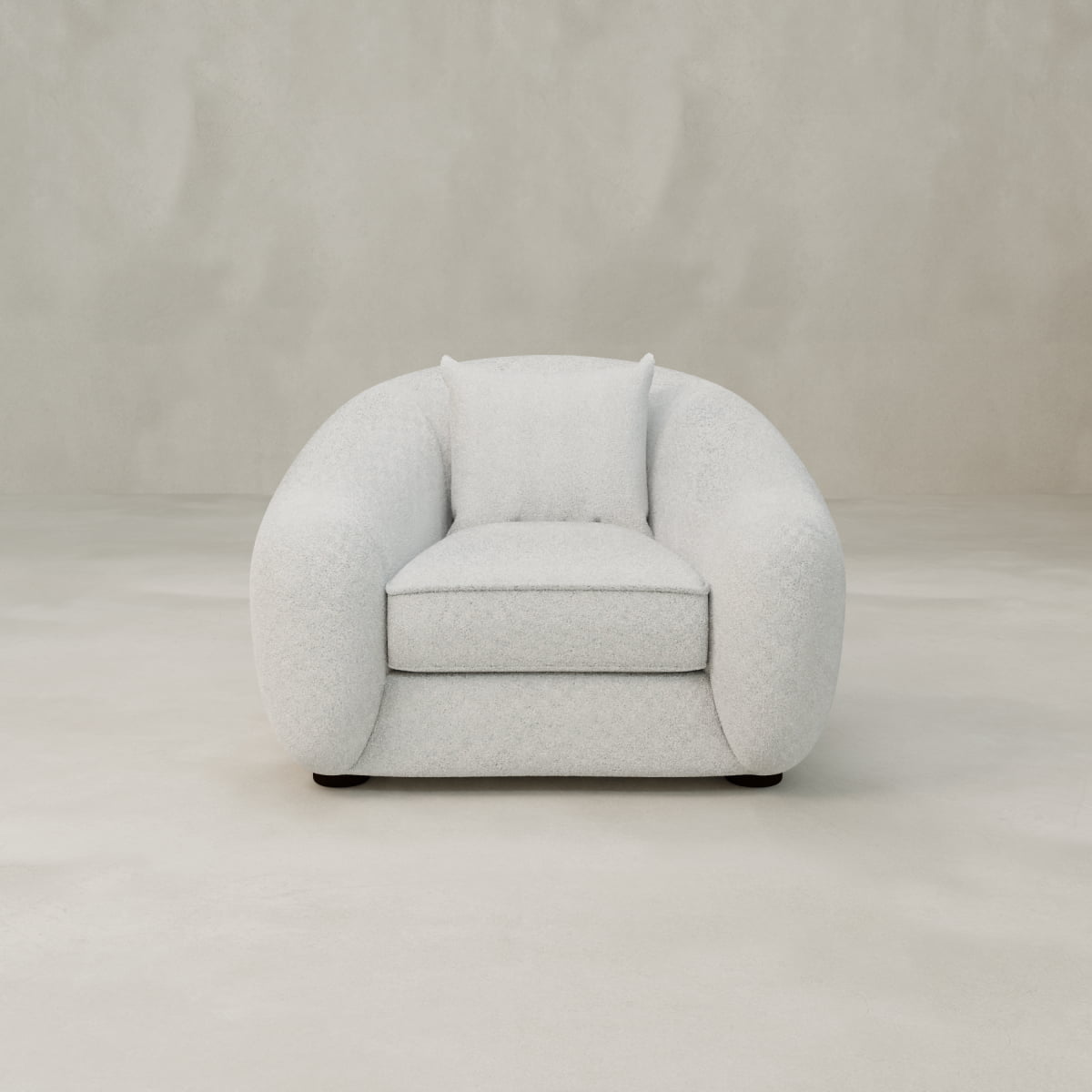 The Polar Bear Armchair features modern, rounded design with plush cushioning and light grey fabric, evoking cozy style against a plain, light-colored background.