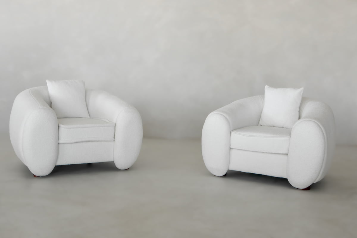 Two Polar Bear Armchairs with rounded arms and backrests, each featuring a single white cushion, are placed side by side on a smooth light gray floor against a matching background.