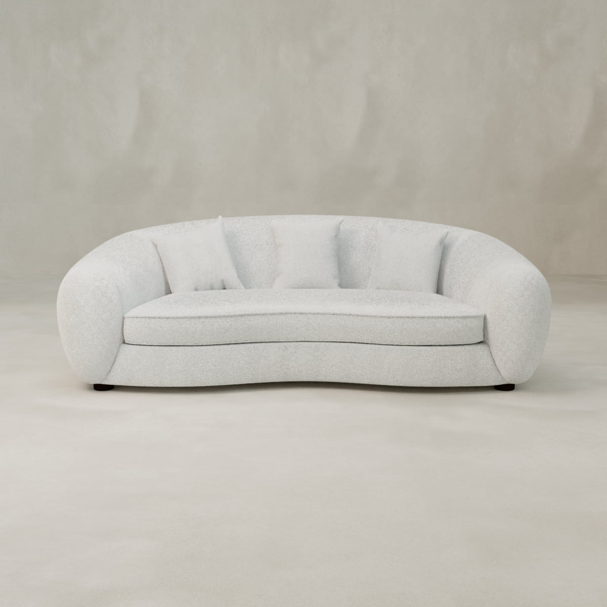 The Polar Bear Sofa, featuring a modern curved white design and plush cushions, sits on a light seamless floor against a textured beige wall—ideal for contemporary design lovers.