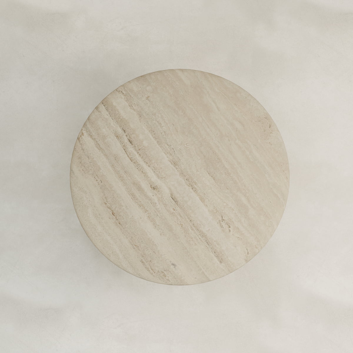 The Renè + Templeton Dining Set features a round travertine dining table, viewed from above, highlighting its natural textured patterns and soft, neutral tones on a light background.