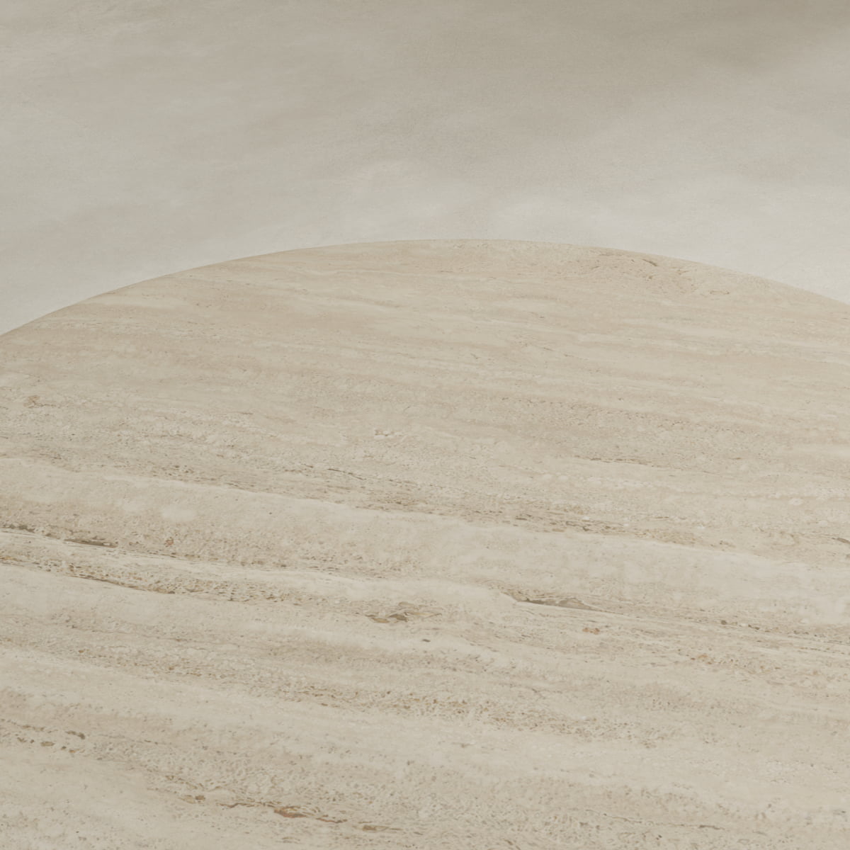 A close-up of the Renè Travertine Dining Table’s round stone surface highlights its natural streaks and textures, set against a smooth, light background—an ideal addition to minimalist spaces.