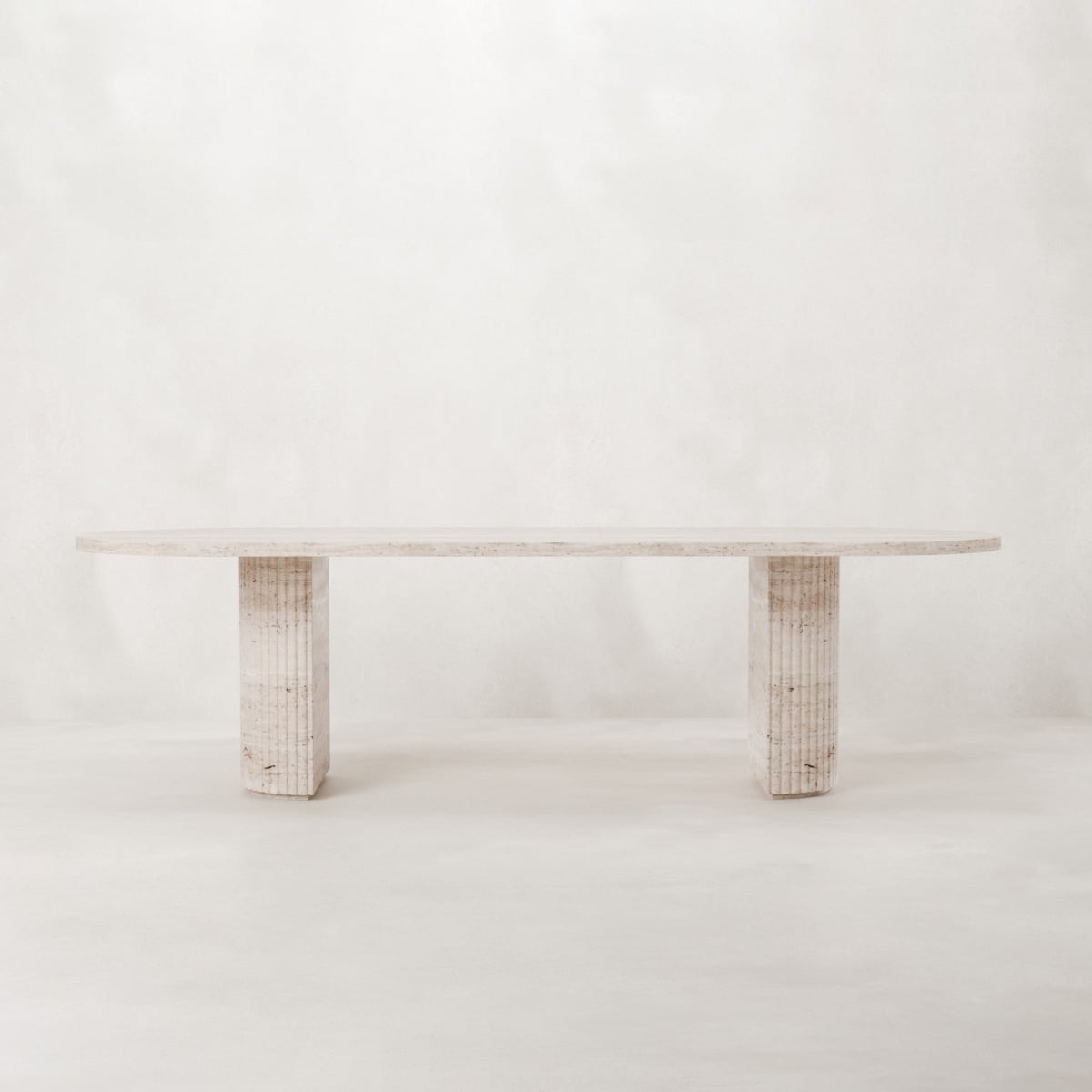 The Richmond Table features a minimalist travertine surface and two textured rectangular legs, displayed on a plain white background—ideal as a sculptural statement piece for any modern interior.