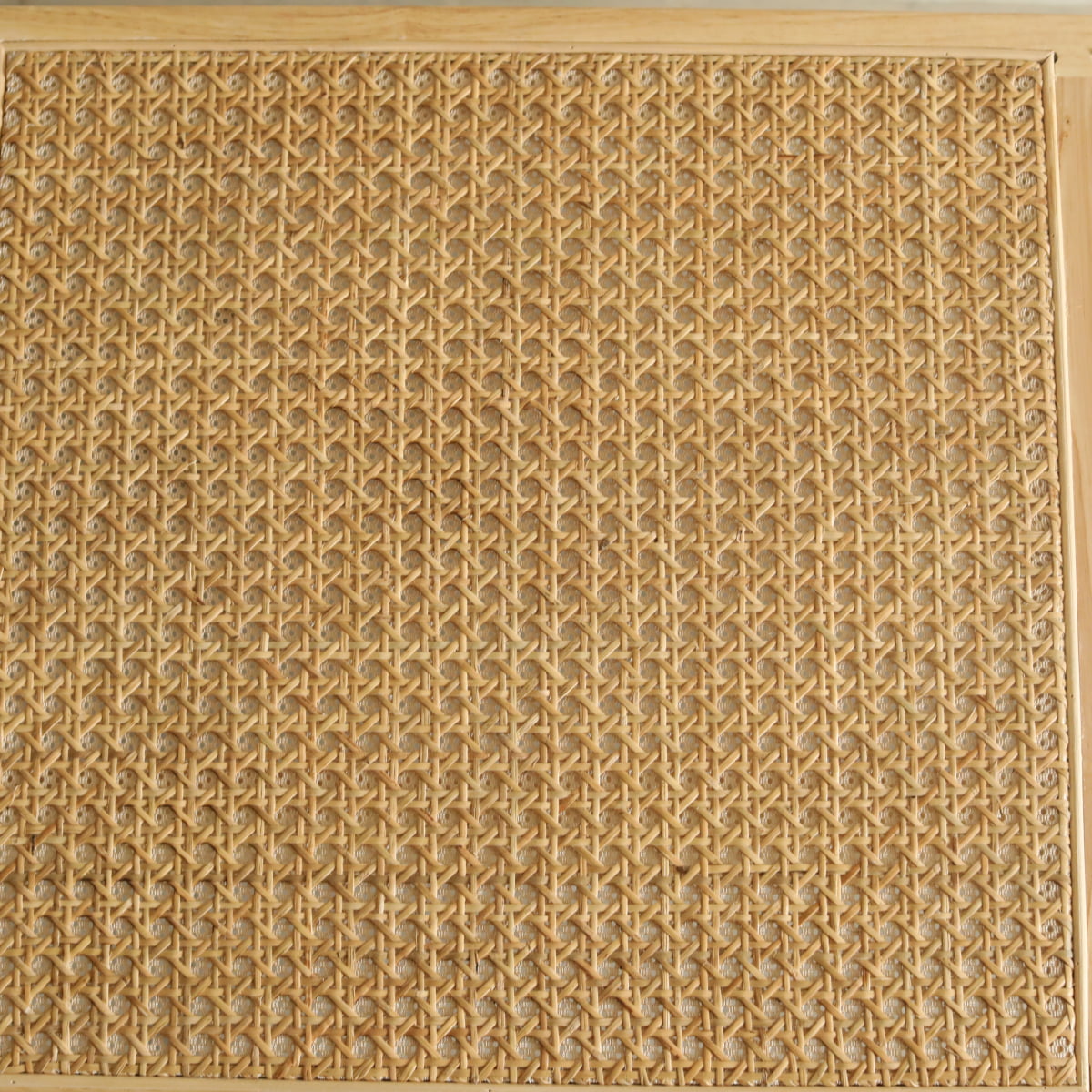 Close-up of the Rivini Bench’s woven rattan panel in a wooden frame, showing intricate cane detailing and an elegant, repeating pattern of interlaced natural fibers.