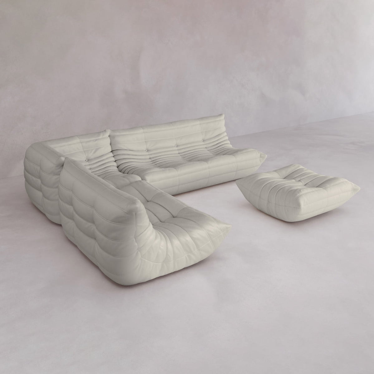 The Rolo Lounge Four Piece Sofa, a modern white sectional with deep tufting, sits on a light minimalist floor with a matching ottoman, while pale walls enhance its clean, contemporary look.