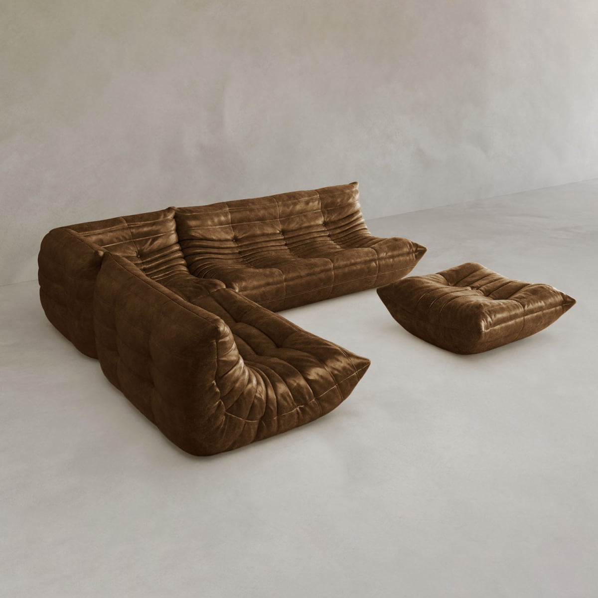 The Rolo Lounge Four Piece Sofa, a modern brown leather sectional with deep tufting and an armless design, is paired with a matching ottoman and set against a light, minimalist background.