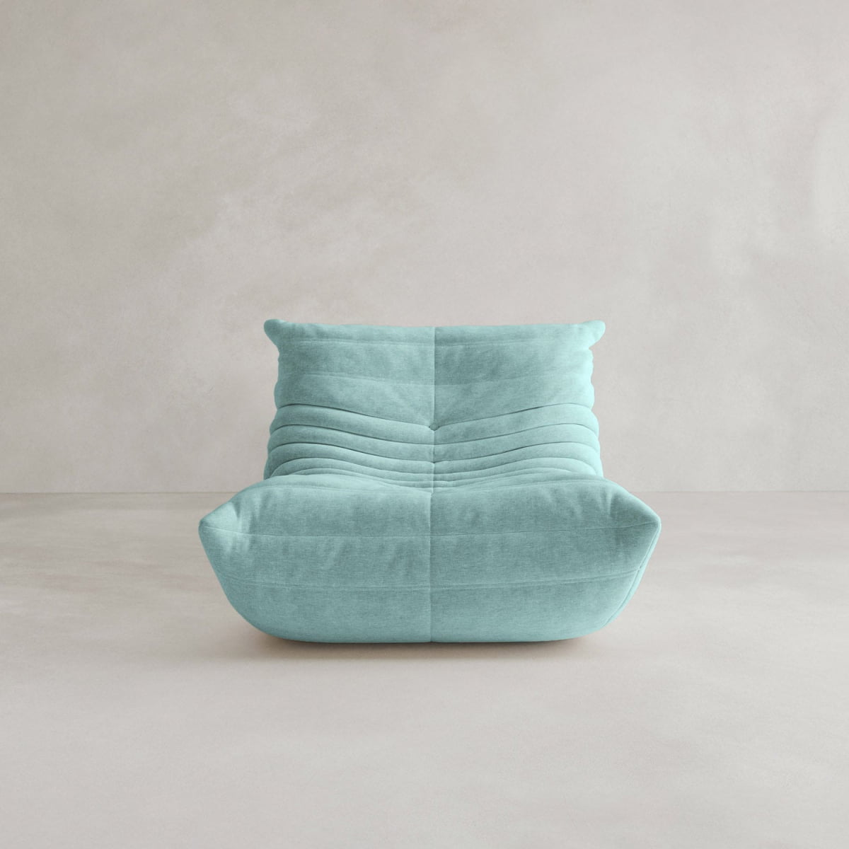 The Rolo Lounge Sofa Chair with Ottoman is a modern armless chair upholstered in soft light blue fabric with horizontal tufting, inspired by 70s design and shown against a plain, light backdrop.
