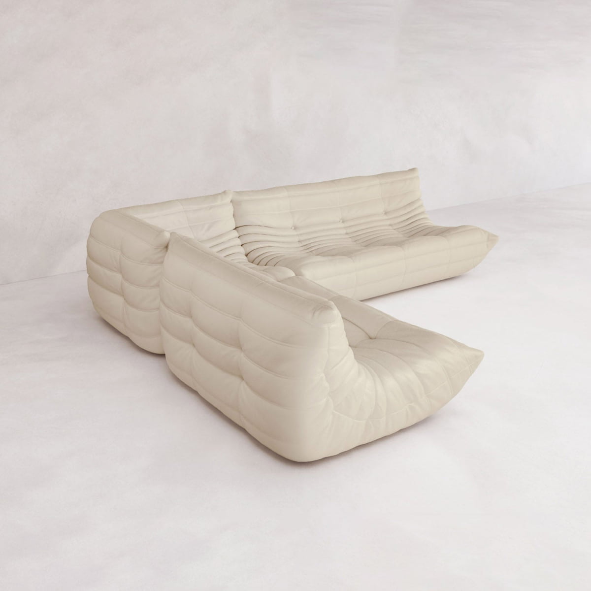 The Rolo Lounge Three Piece Sofa, a modern cream modular design with tufted upholstery, is arranged in an L-shape on a minimalistic background, showcasing its versatile mid-century inspired modular system.
