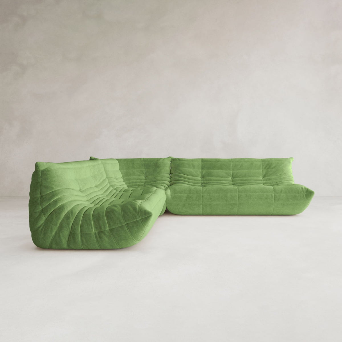 The Rolo Lounge Three Piece Sofa, featuring a modern green design and tufted cushions inspired by mid-century style, is displayed on a white floor against a light grey textured wall.