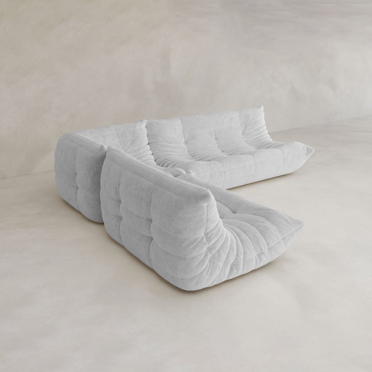 The Rolo Lounge Three Piece Sofa features a modern, tufted cushioned design in light gray with no visible legs, bringing effortless style to minimalist spaces with neutral walls and floors.