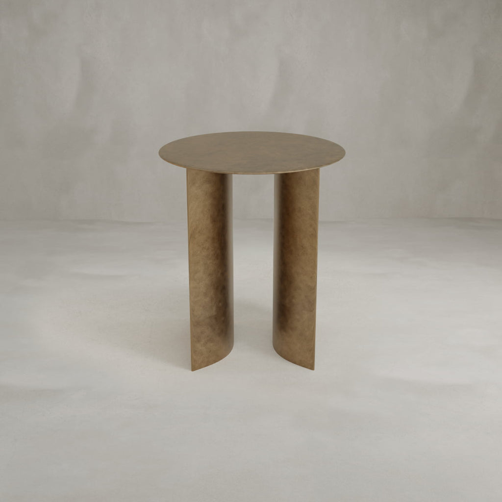 The Roma Coffee Table Tall features a modern round bronze finish with a flat top and two wide, curved legs, set against a neutral light gray textured background.