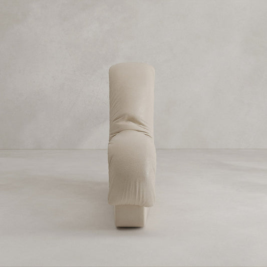 The Serpenti Sofa Armrest Module is a modern, minimalist piece upholstered in light beige leather with soft, rounded edges and a plush, sculptural design inspired by modular sofas for versatile comfort. Shown from the front against a plain background.