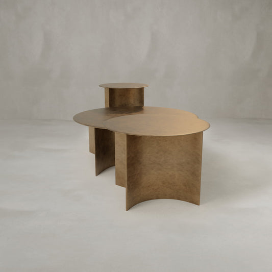 The Set of Roma Tables features sculptural bronze tones with overlapping circular surfaces at different heights and curved supports—ideal for enhancing your decor in a minimalist light gray room.