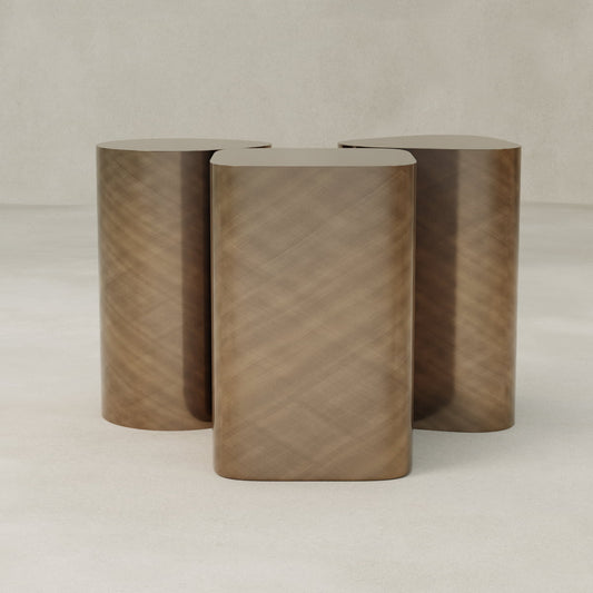 The Set of Solaris Side Table features three cylindrical, light brown wooden stools with rounded edges and a minimalist design, displayed together on a plain, light surface against a neutral background.