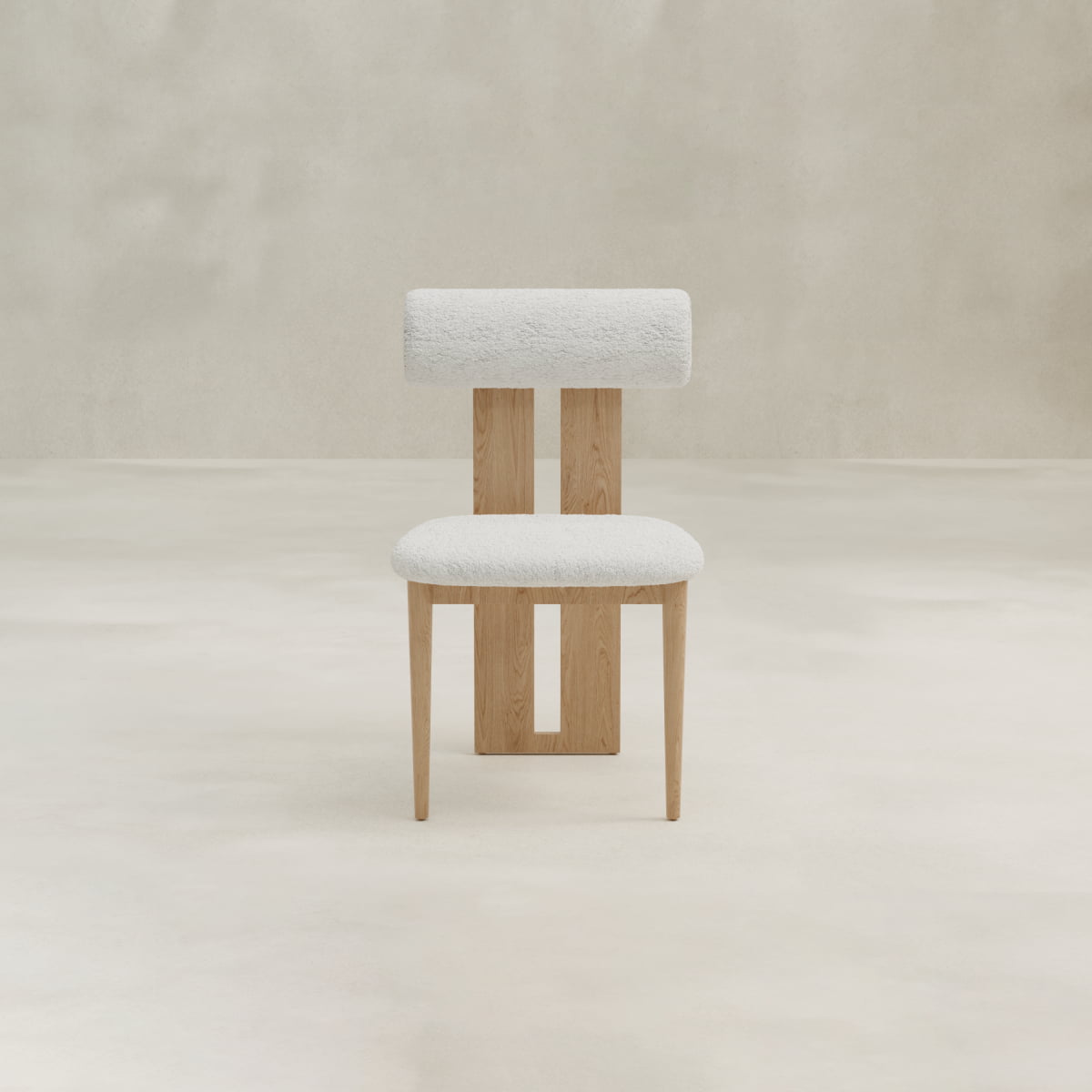 The Renè + Templeton Dining Set features a modern chair with light wood legs, a plush white upholstered seat, and a cylindrical backrest, paired with a travertine dining table against a minimal beige backdrop.