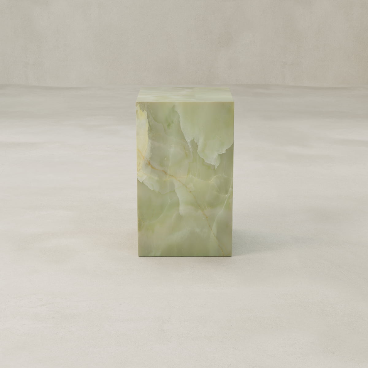 The Verdaine Onyx Plinth - Tall, crafted from light green onyx with natural veining, adds a sculptural touch and enhances contemporary spaces when placed on a smooth, light-colored surface against a neutral background.