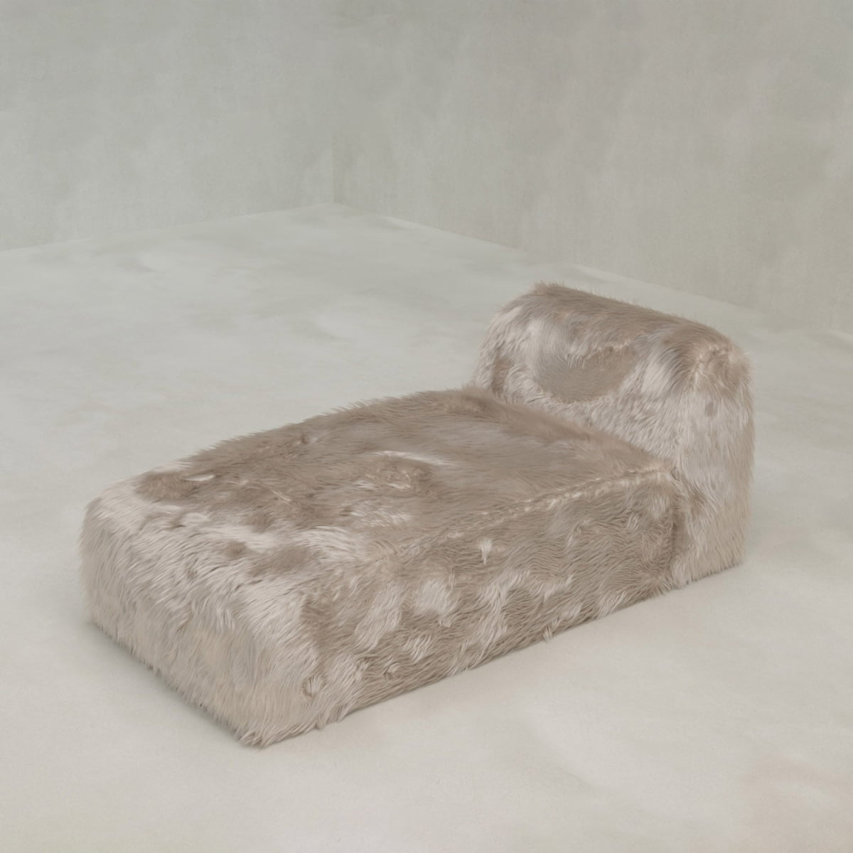 The Yeti Chaise Lounge, with a backrest and fully wrapped in plush light beige faux fur, offers luxurious comfort in a minimalist space with pale walls and floor.