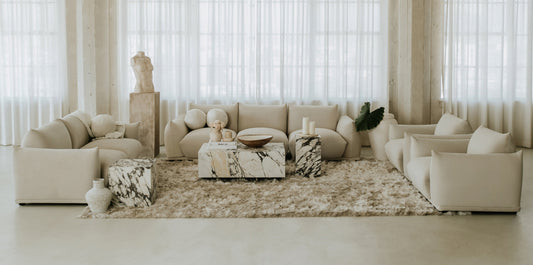 Luxury sofa in premium fabric finish paired with a vintage leather sofa, styled with layered rugs and modern lighting.