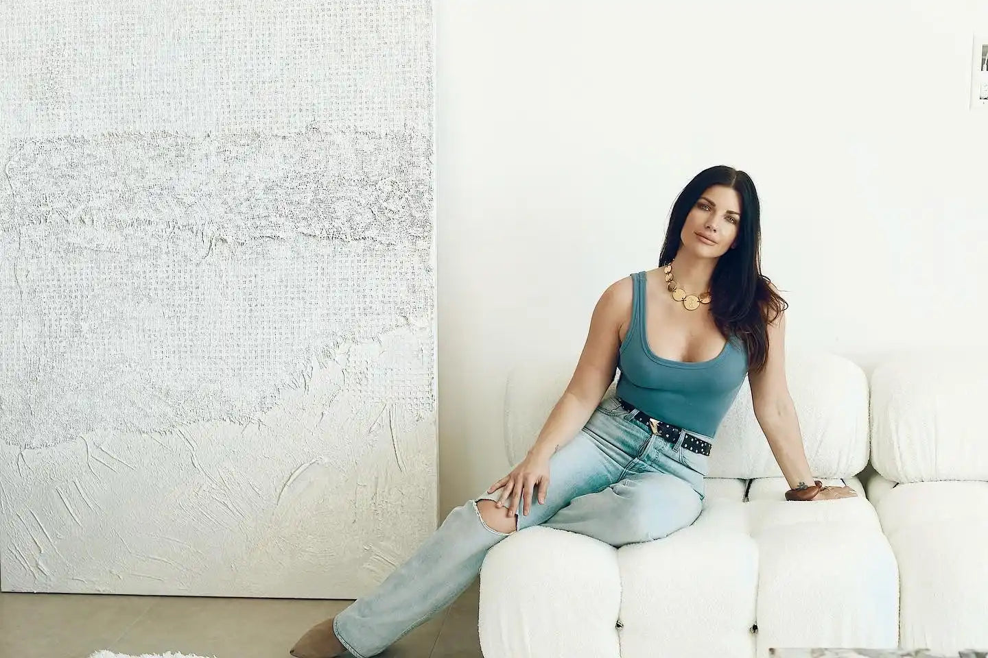 Woman in blue top and ripped jeans