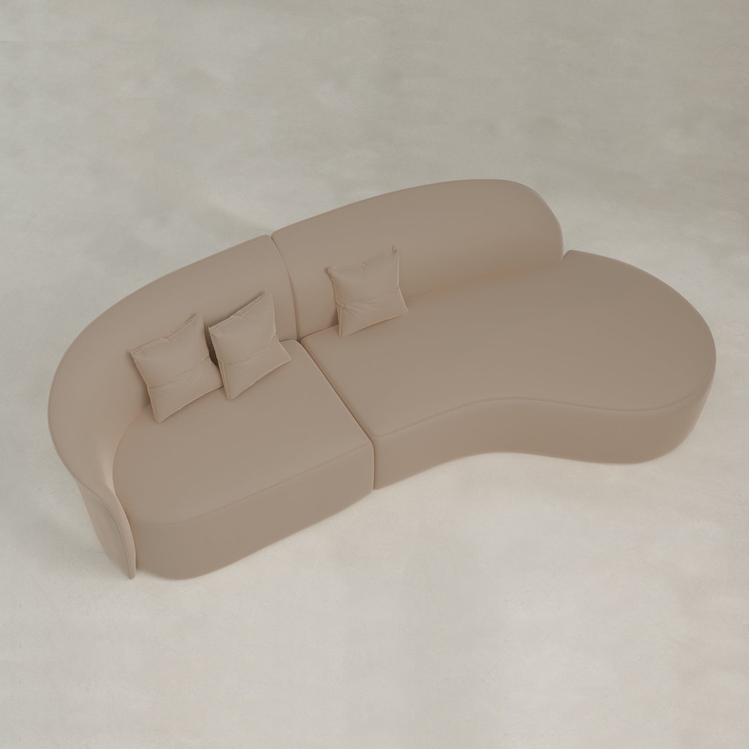 The Marlow Curved Modular Three Seater Sofa features beige velvet upholstery and includes three matching square pillows, shown from above on a light-colored floor.
