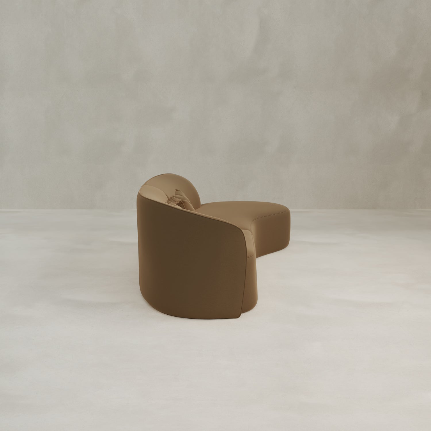 The Marlow Curved Modular Three Seater Sofa, featuring a modern sculptural design and luxurious upholstery, sits on a smooth light floor against a textured beige wall.