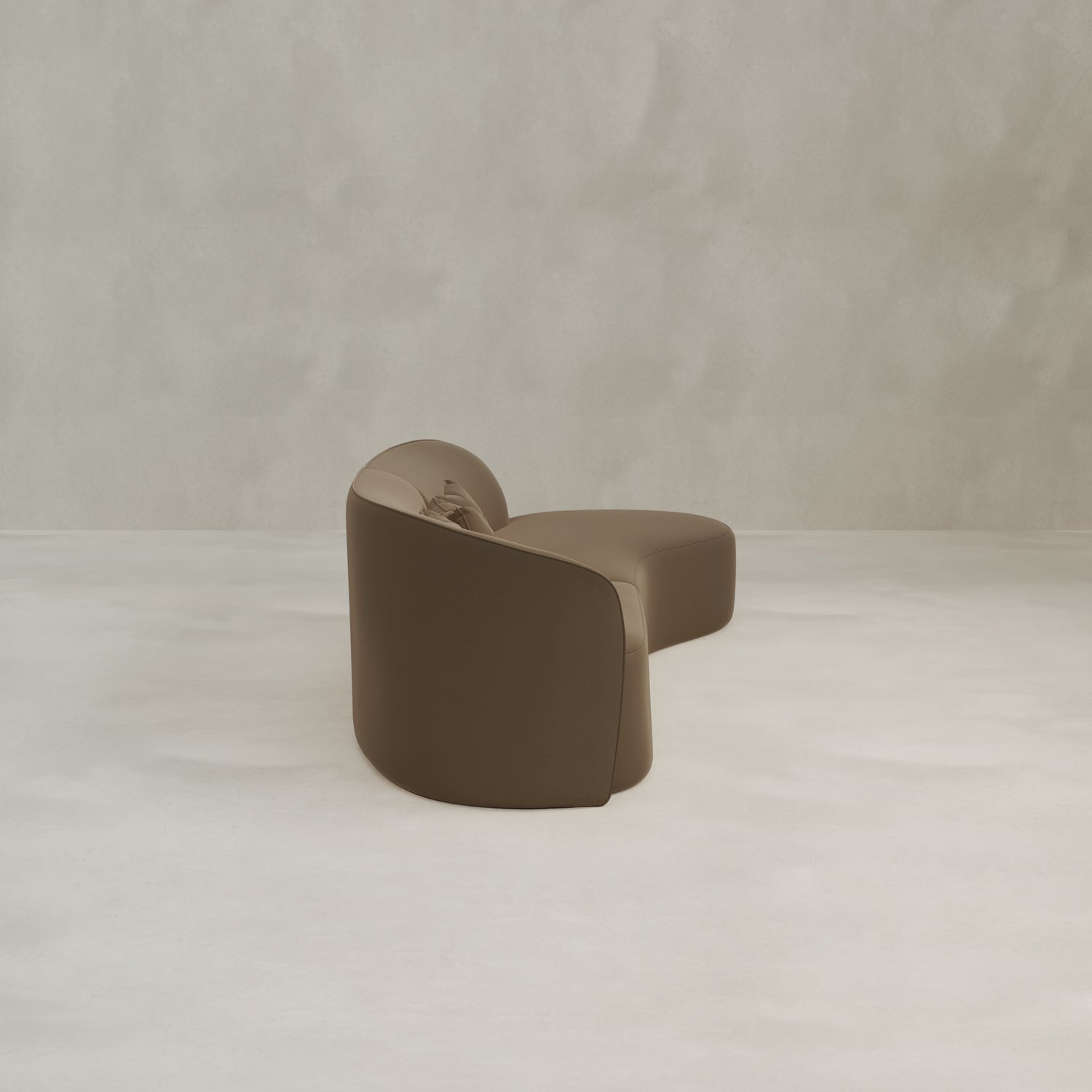 The Marlow Curved Modular Three Seater Sofa features a modern brown design with luxurious upholstery, placed on a light textured floor against a neutral plain wall.