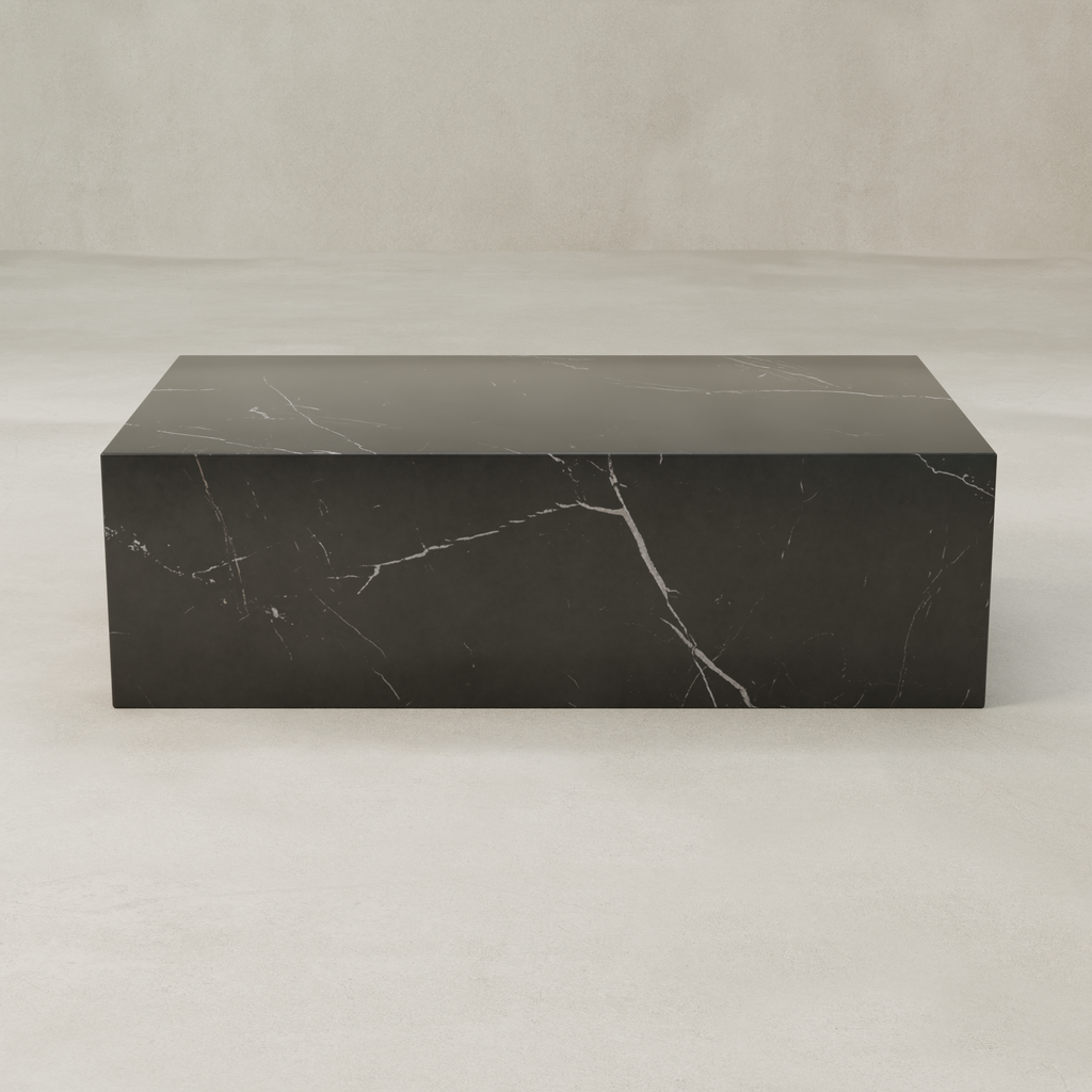 The Obscara Coffee Table, a rectangular black marble piece with white veining, adds architectural drama to the space, set on a light textured floor against a neutral beige background.